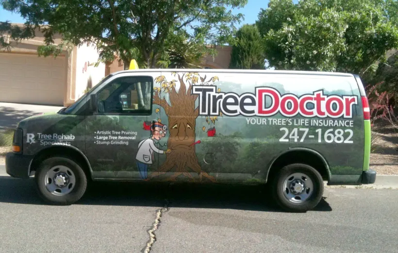 Tree Doctor service van parked outdoors, with large logo and phone number on the side.