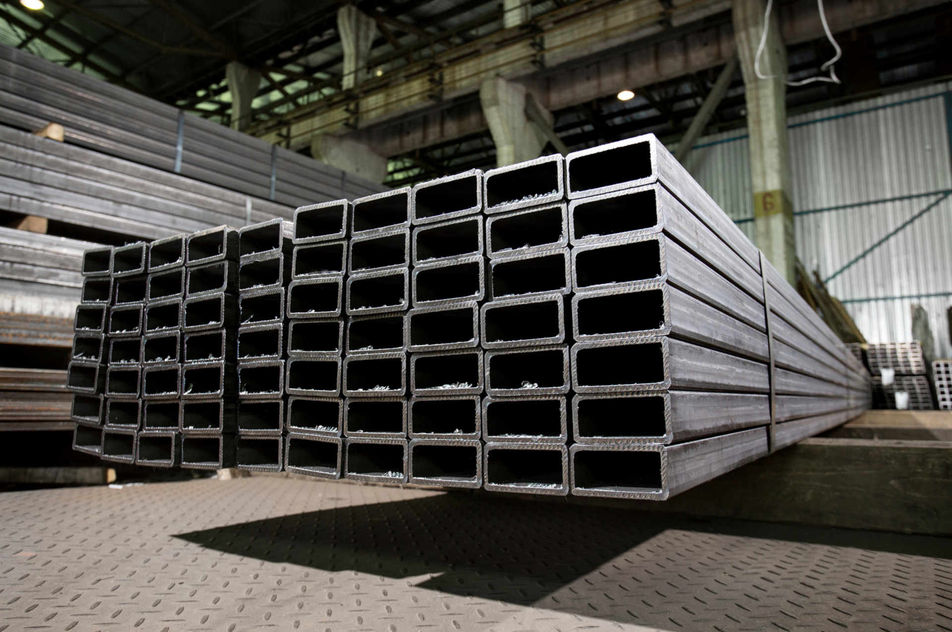 Un entrepôt rempli de piles de tuyaux métalliques