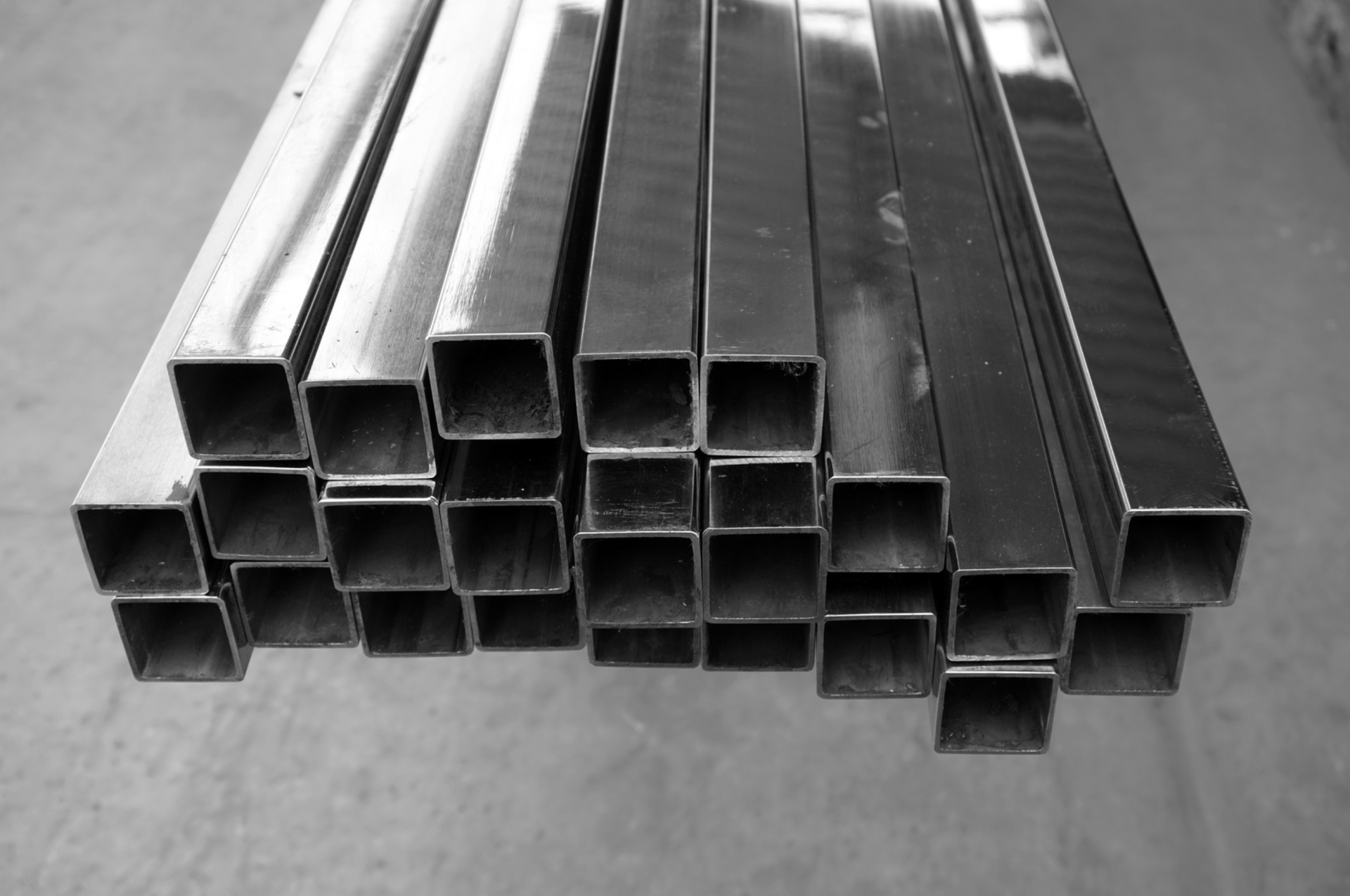 Une photo en noir et blanc d'une pile de tuyaux métalliques carrés