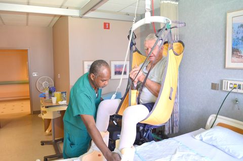 Nurse using Bed Lift Device on an old man
