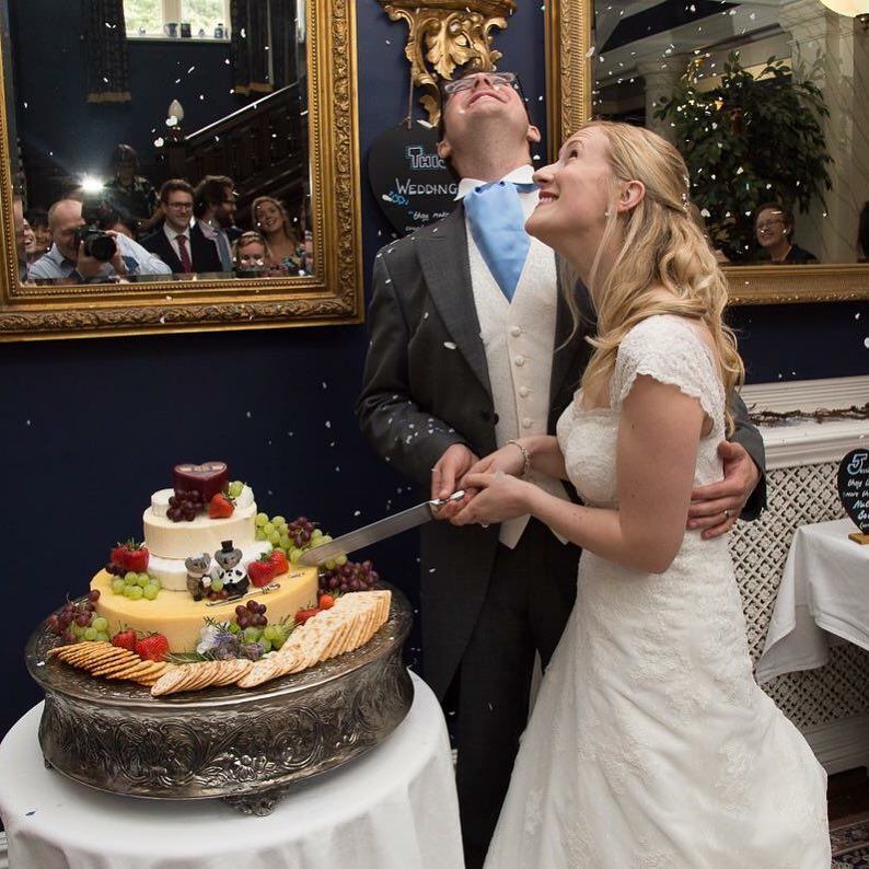 A bride and groom are cutting their wedding cake