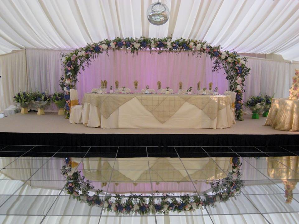 A table with flowers on it and a mirrored dance floor