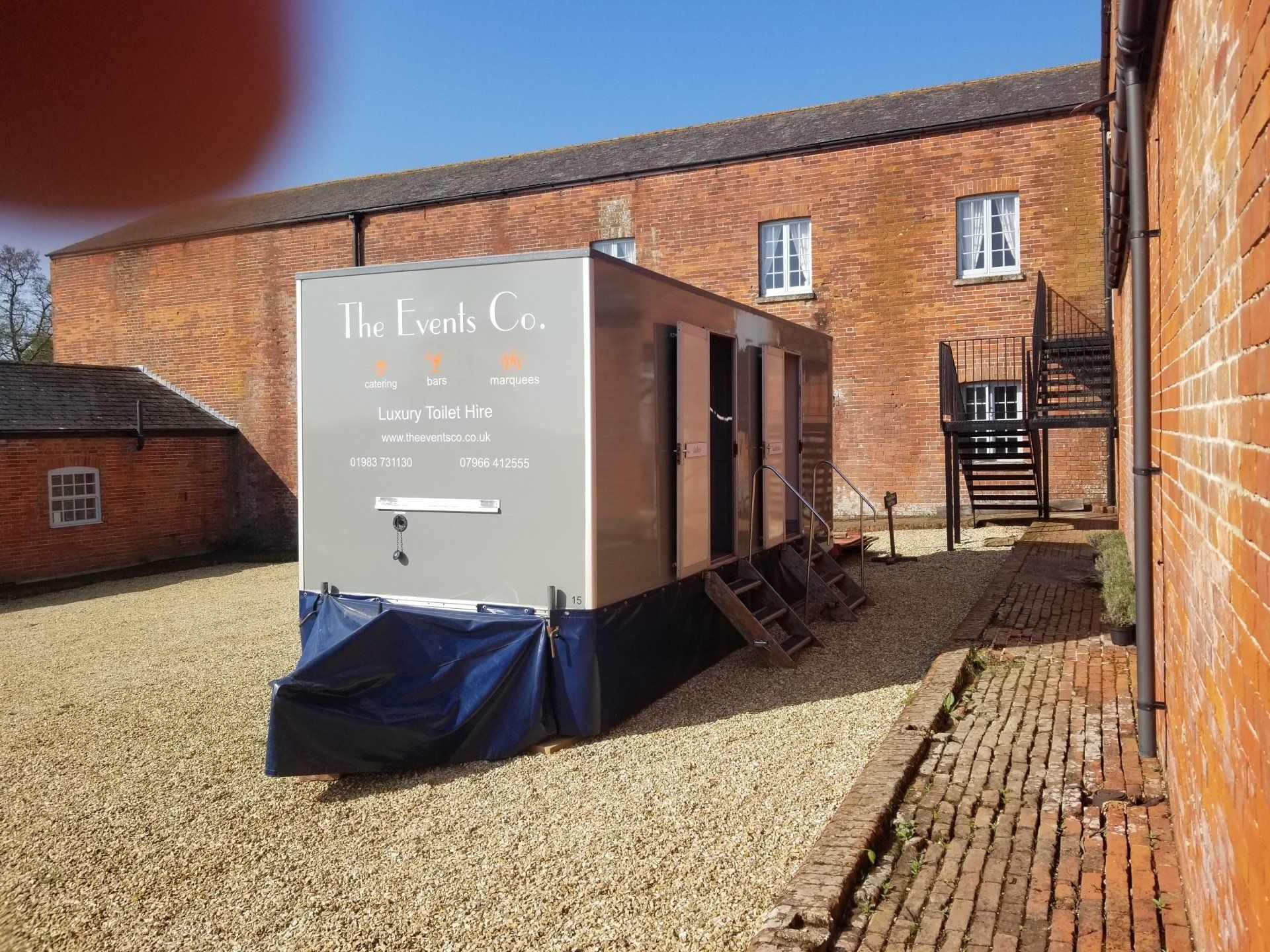 A trailer is parked in front of a brick building.
