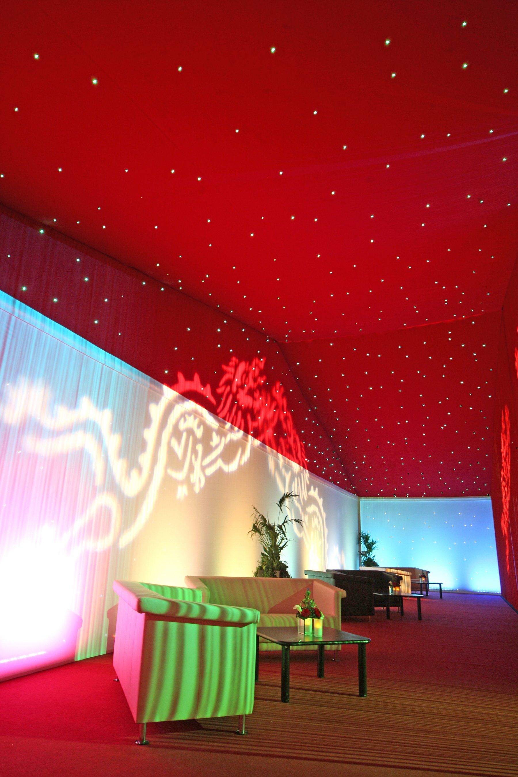 A room with a red ceiling and green chairs