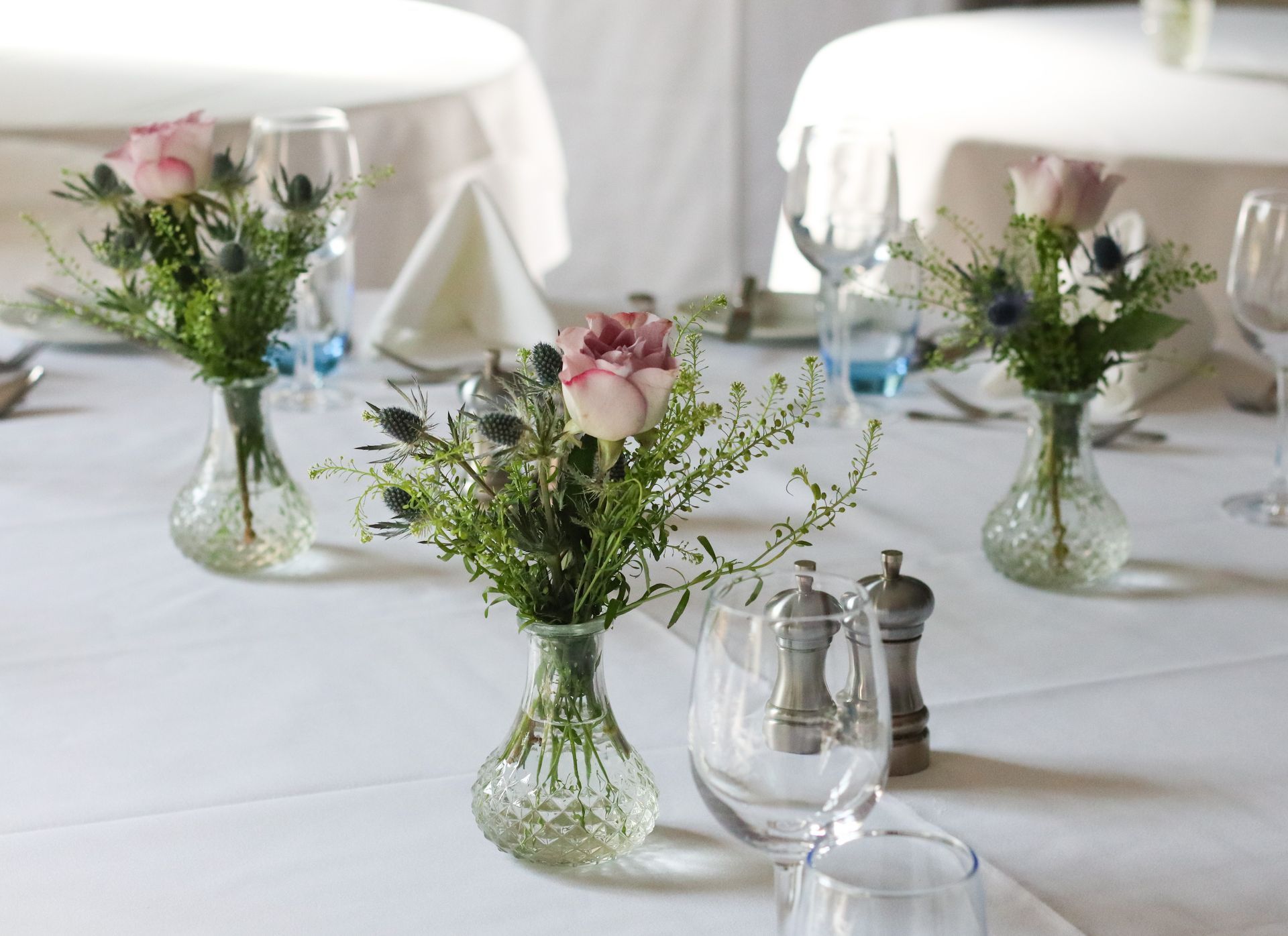 A table with flowers in vases and salt and pepper shakers