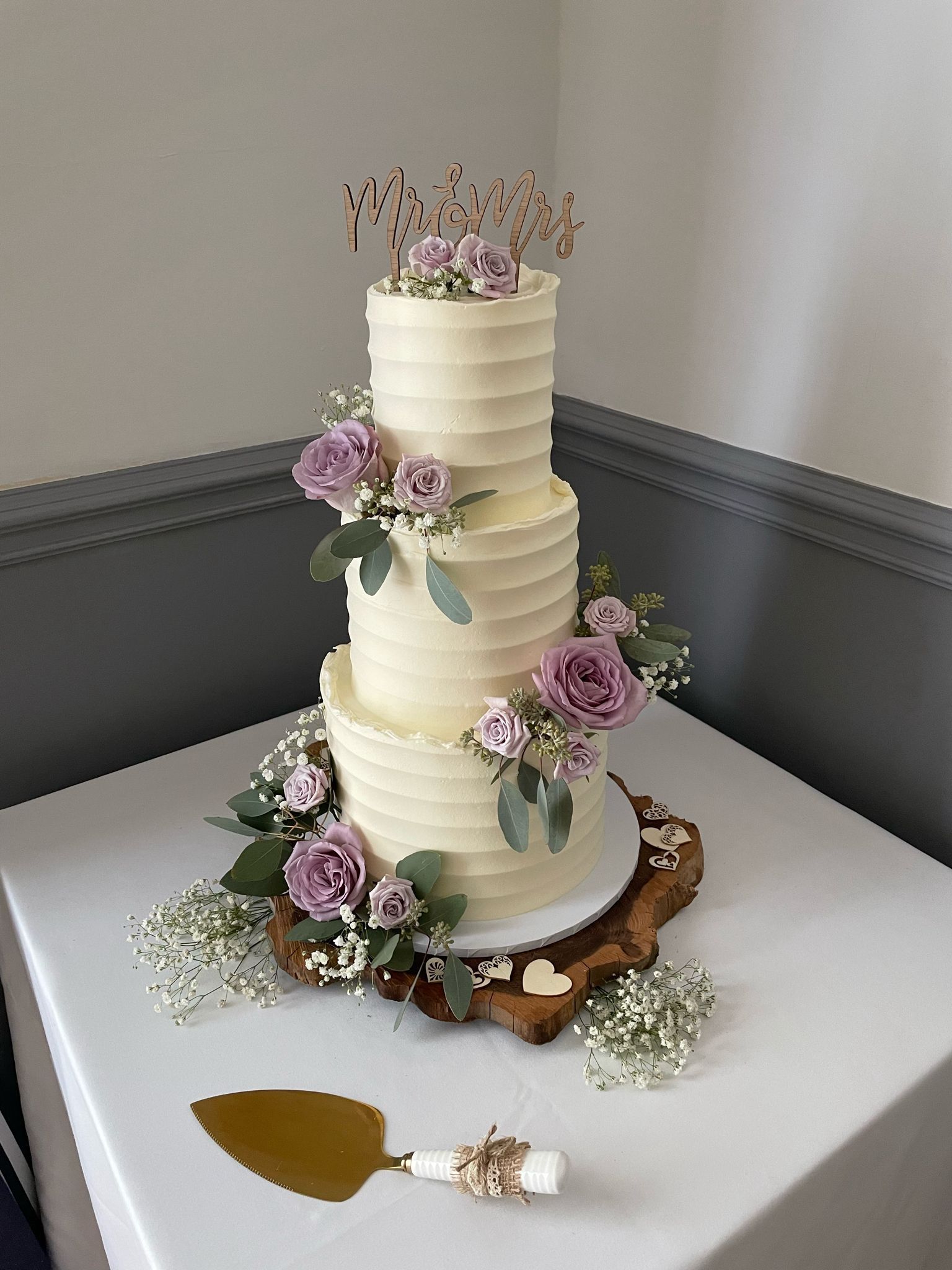 A wedding cake is sitting on top of a white table.