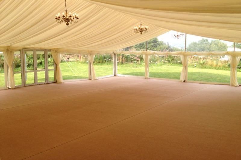 A large empty tent with a chandelier hanging from the ceiling.