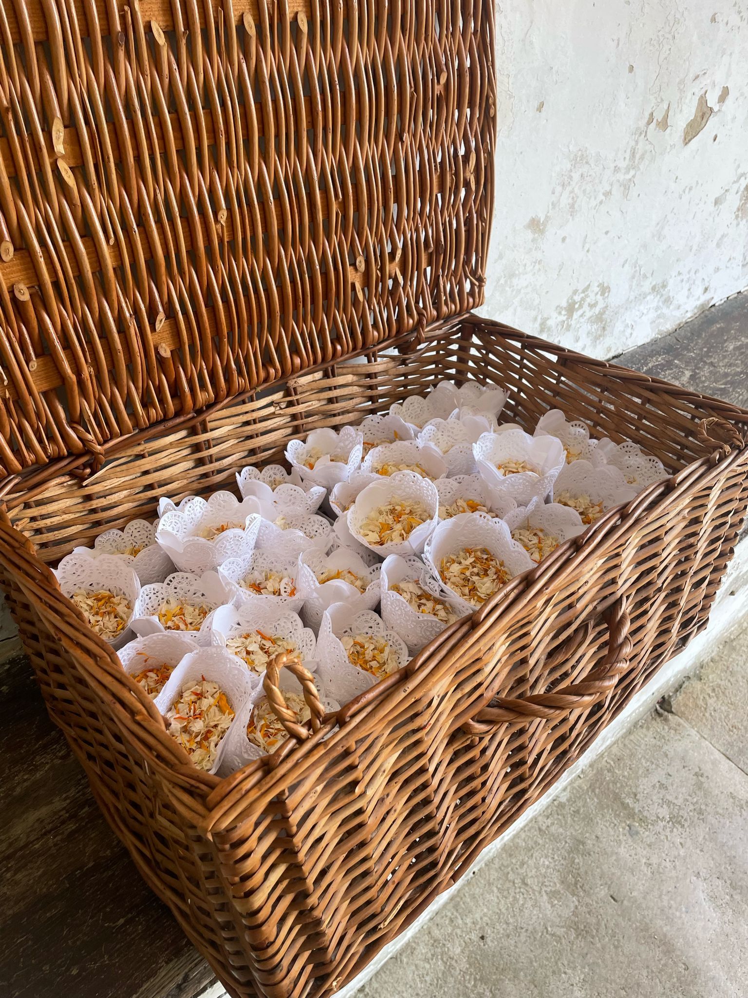 A wicker basket filled with cupcakes on a table.