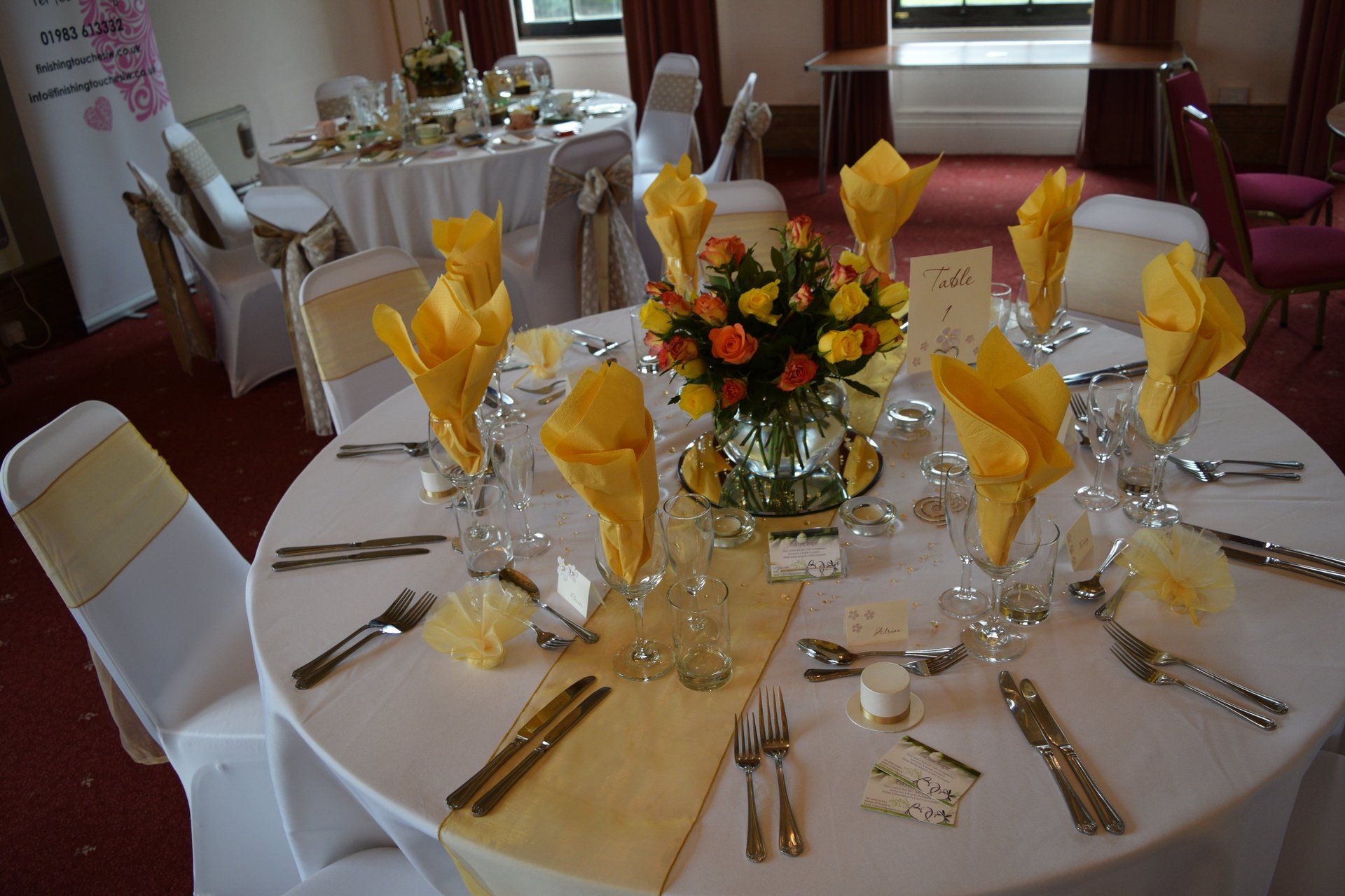 A table with a vase of yellow flowers on it