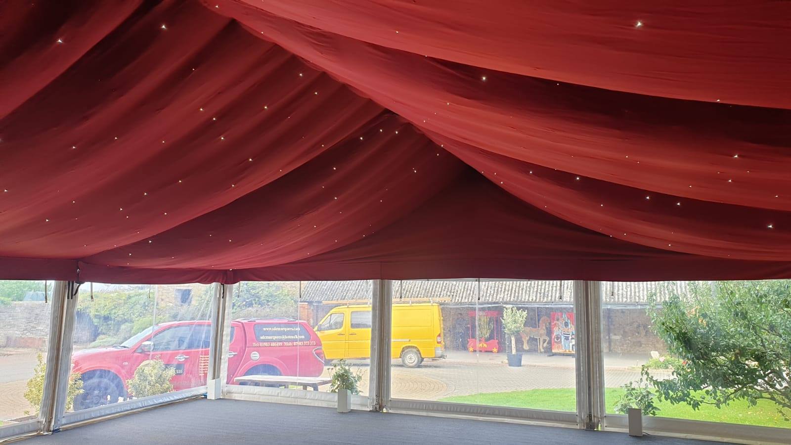 The inside of a tent with a red ceiling and lights.