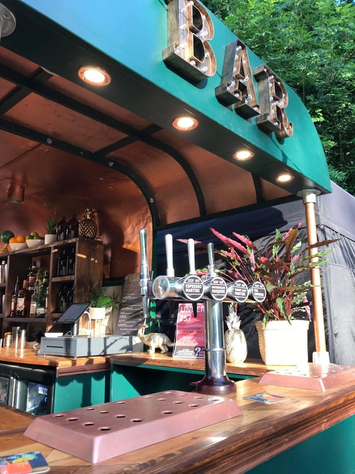 A bar with a green awning and a tap on the counter.