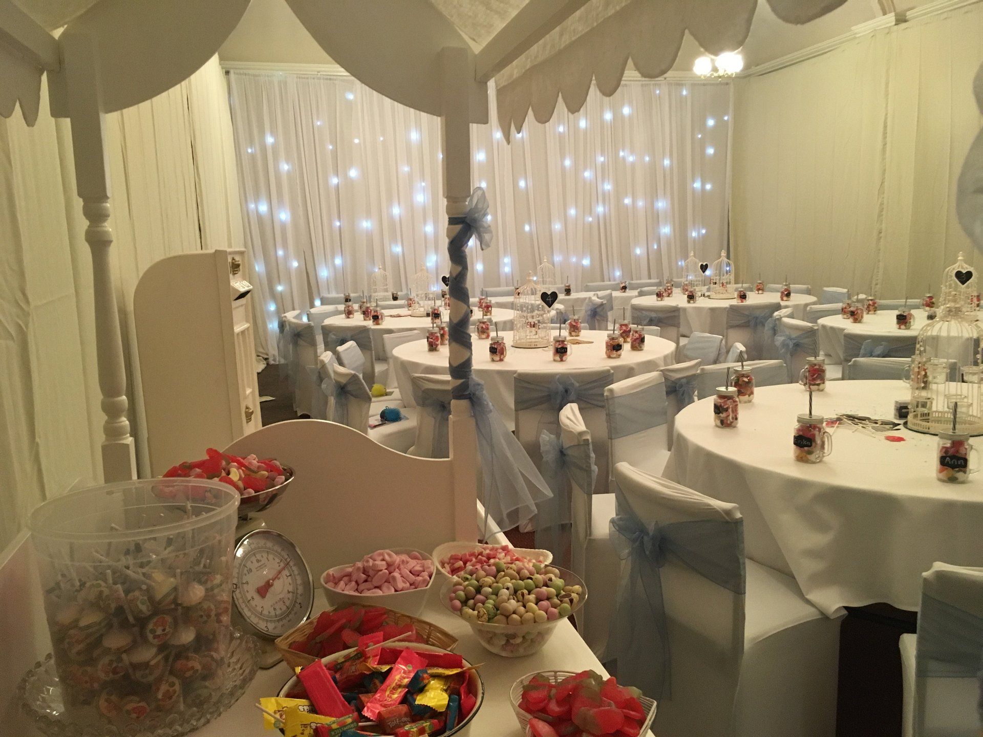 A room with tables and chairs set up for a wedding reception.