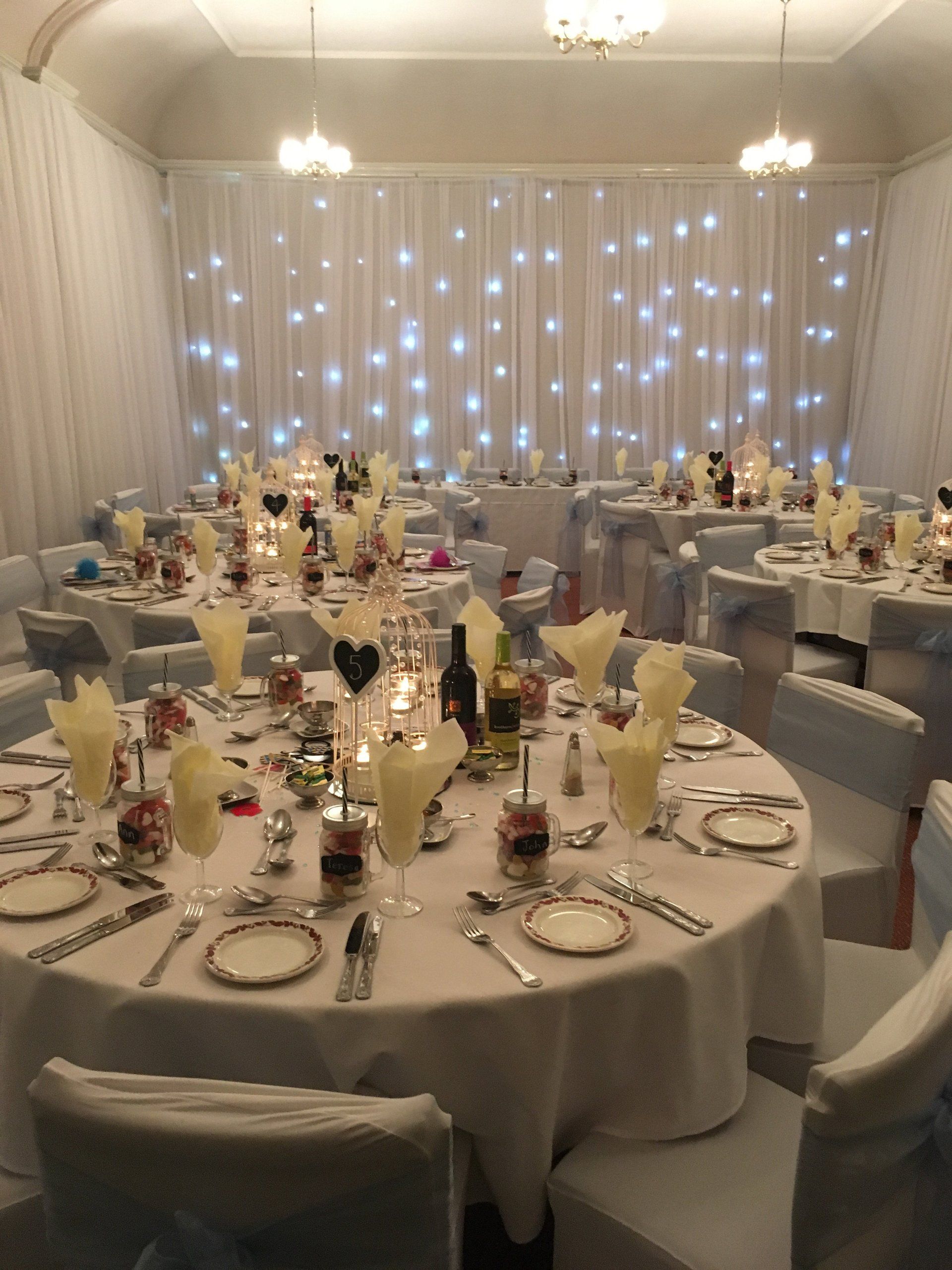 A large room with tables and chairs set up for a wedding reception.