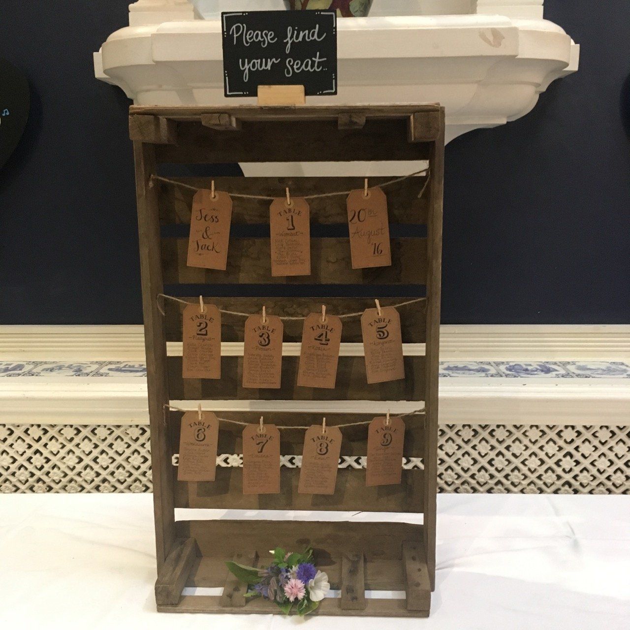 A wooden crate with a sign that says please find your seat