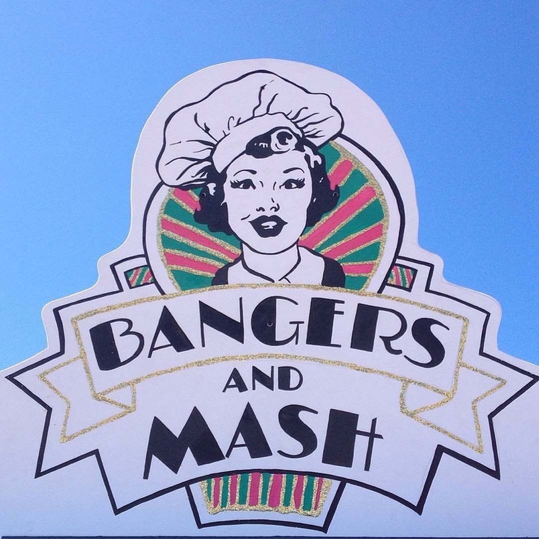 A sign for bangers and mash shows a woman wearing a chef 's hat