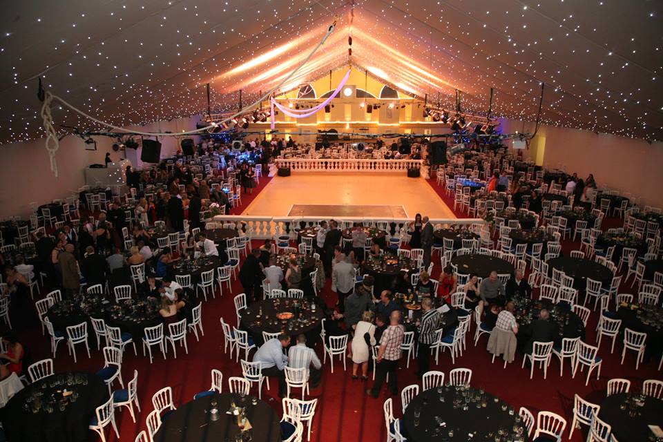 A large room with tables and chairs and a dance floor