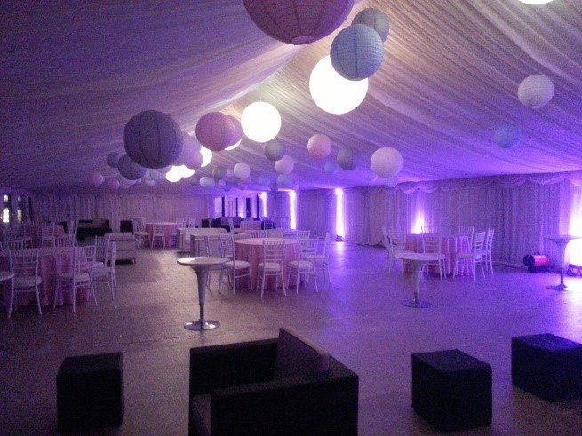 A large room with tables and chairs and purple lights