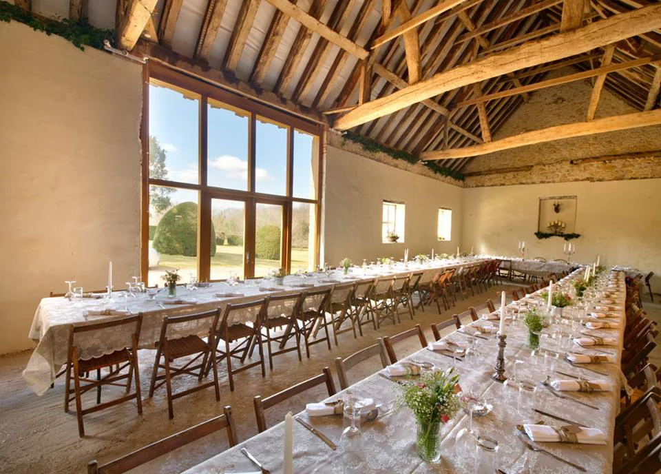 A large room with a long table and chairs set up for a banquet.