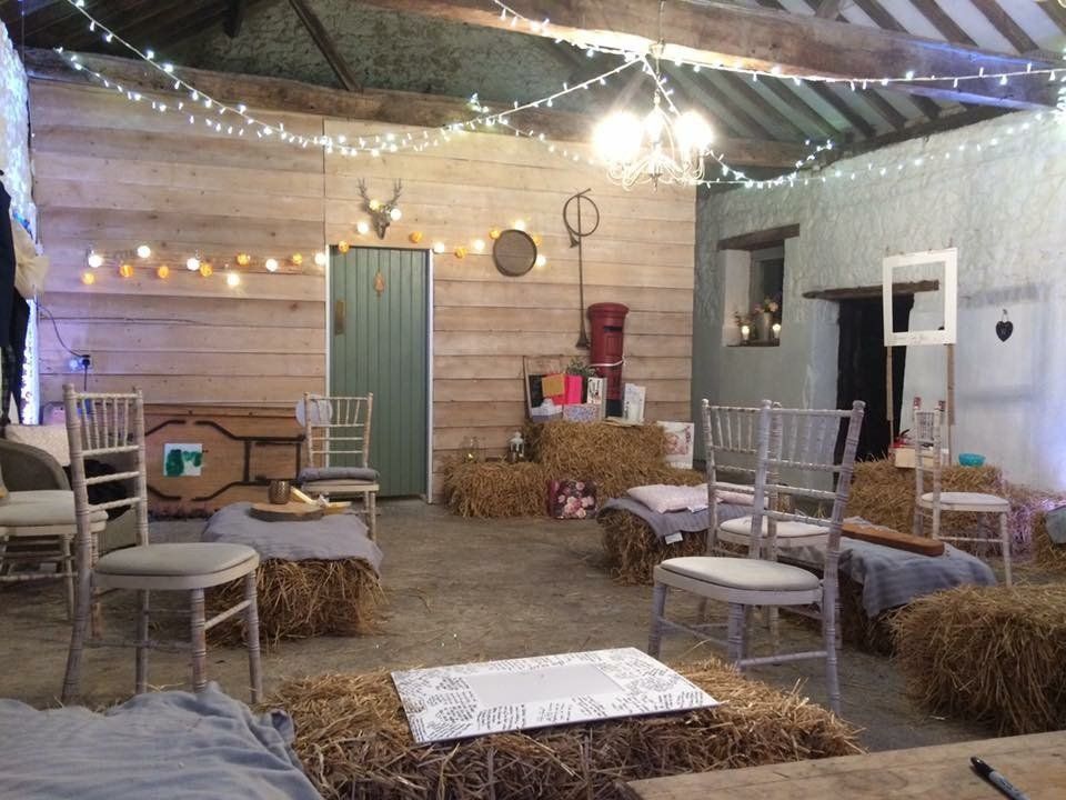 A room with hay bales and chairs in it