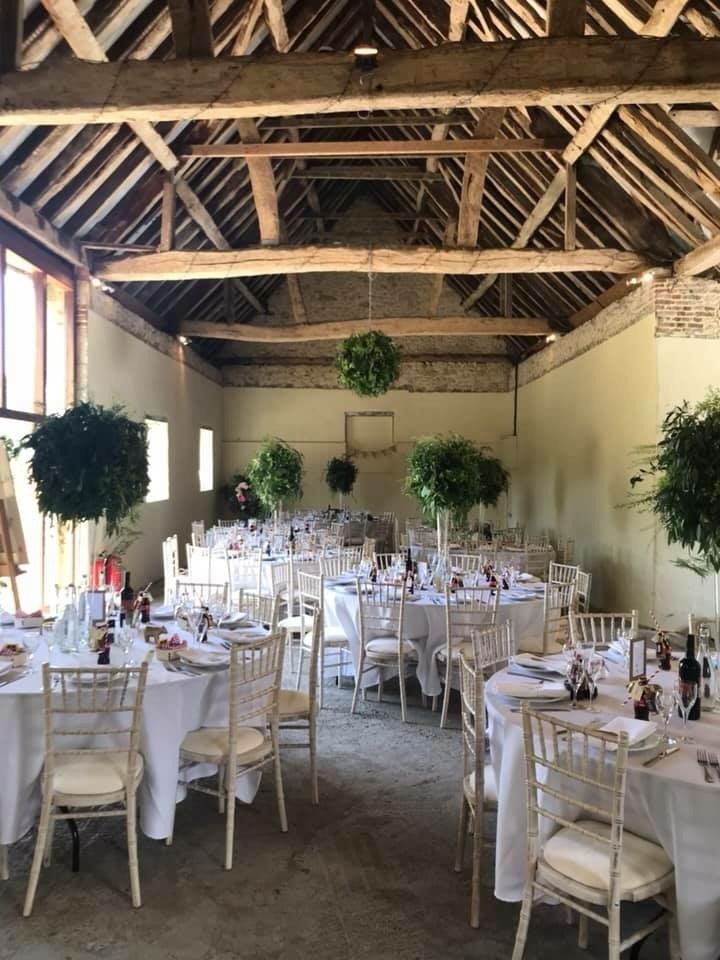 A large room with tables and chairs set up for a wedding reception.