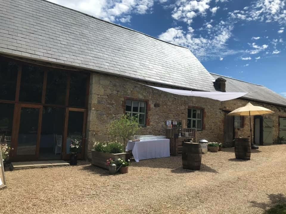 A large stone building with a table and umbrellas in front of it.