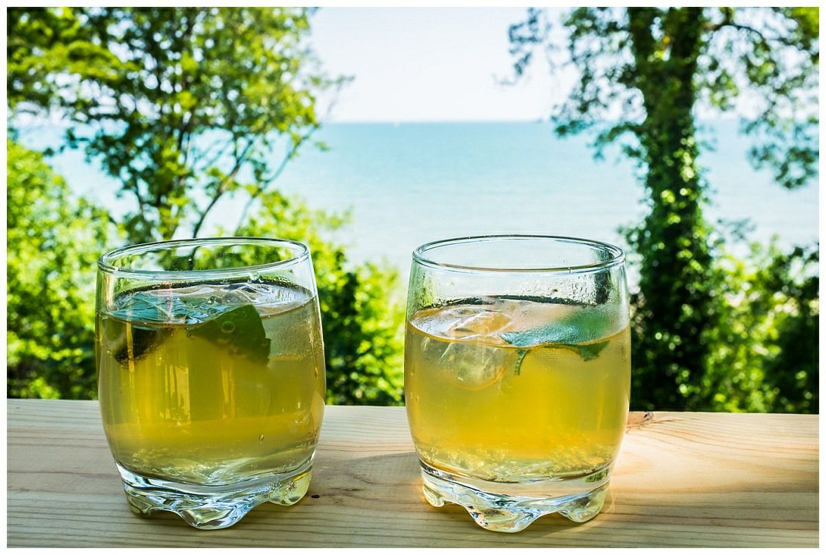 Two glasses of green liquid are sitting on a wooden table.