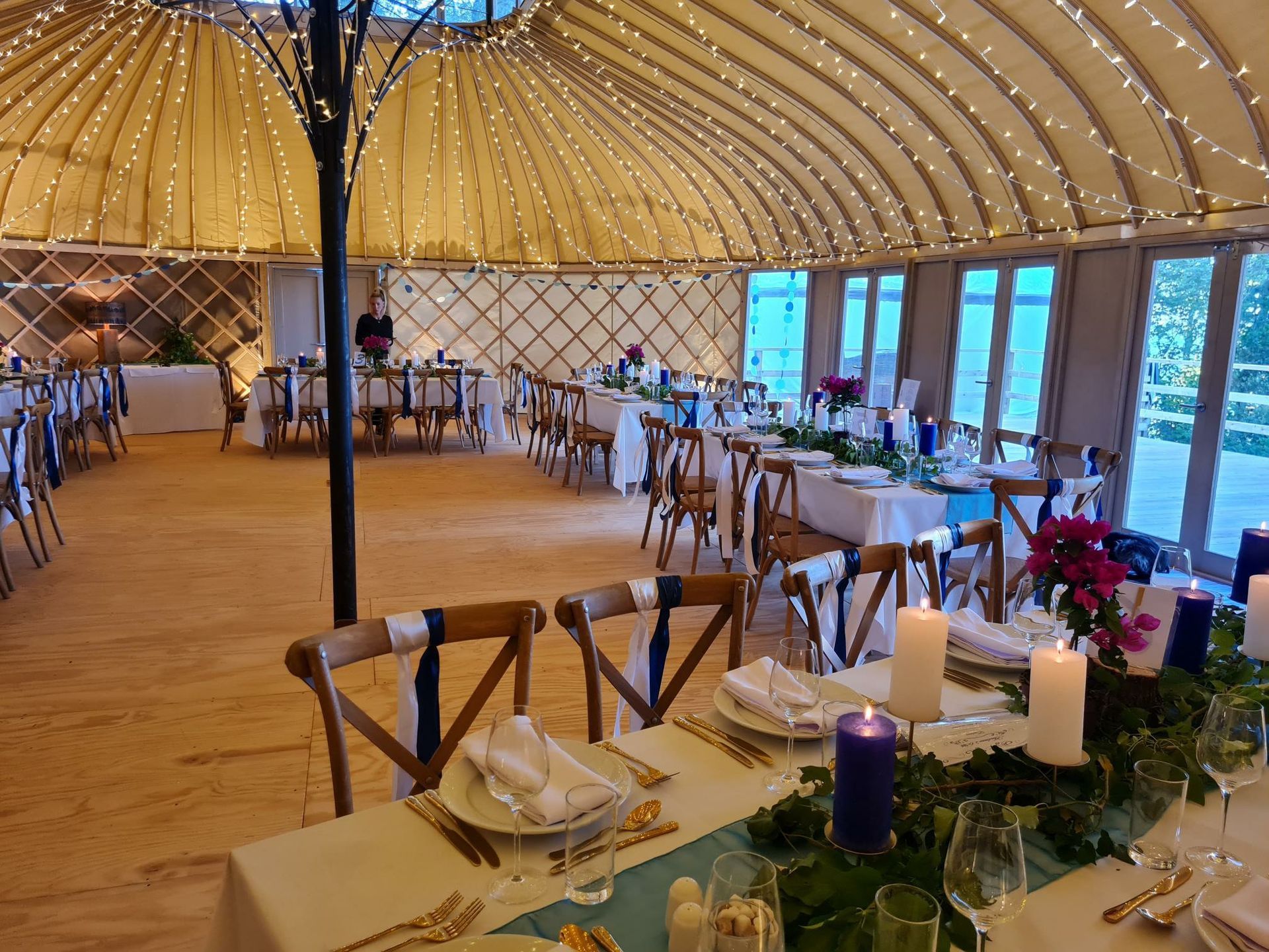 A large room with tables and chairs set up for a wedding reception.