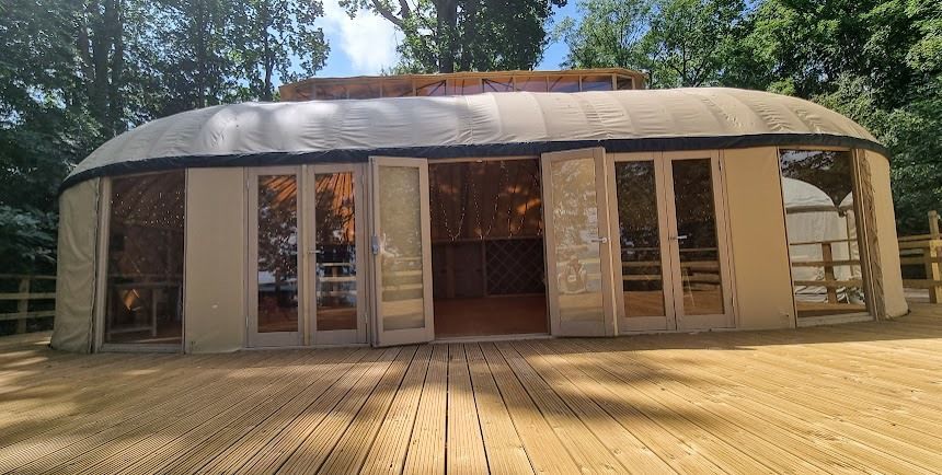 A large tent is sitting on top of a wooden deck.