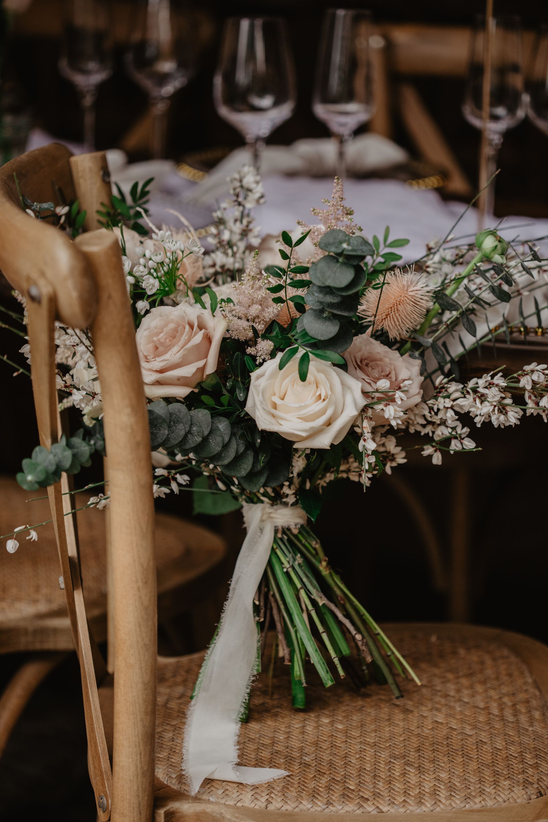 A bouquet of flowers is sitting on a wooden chair.