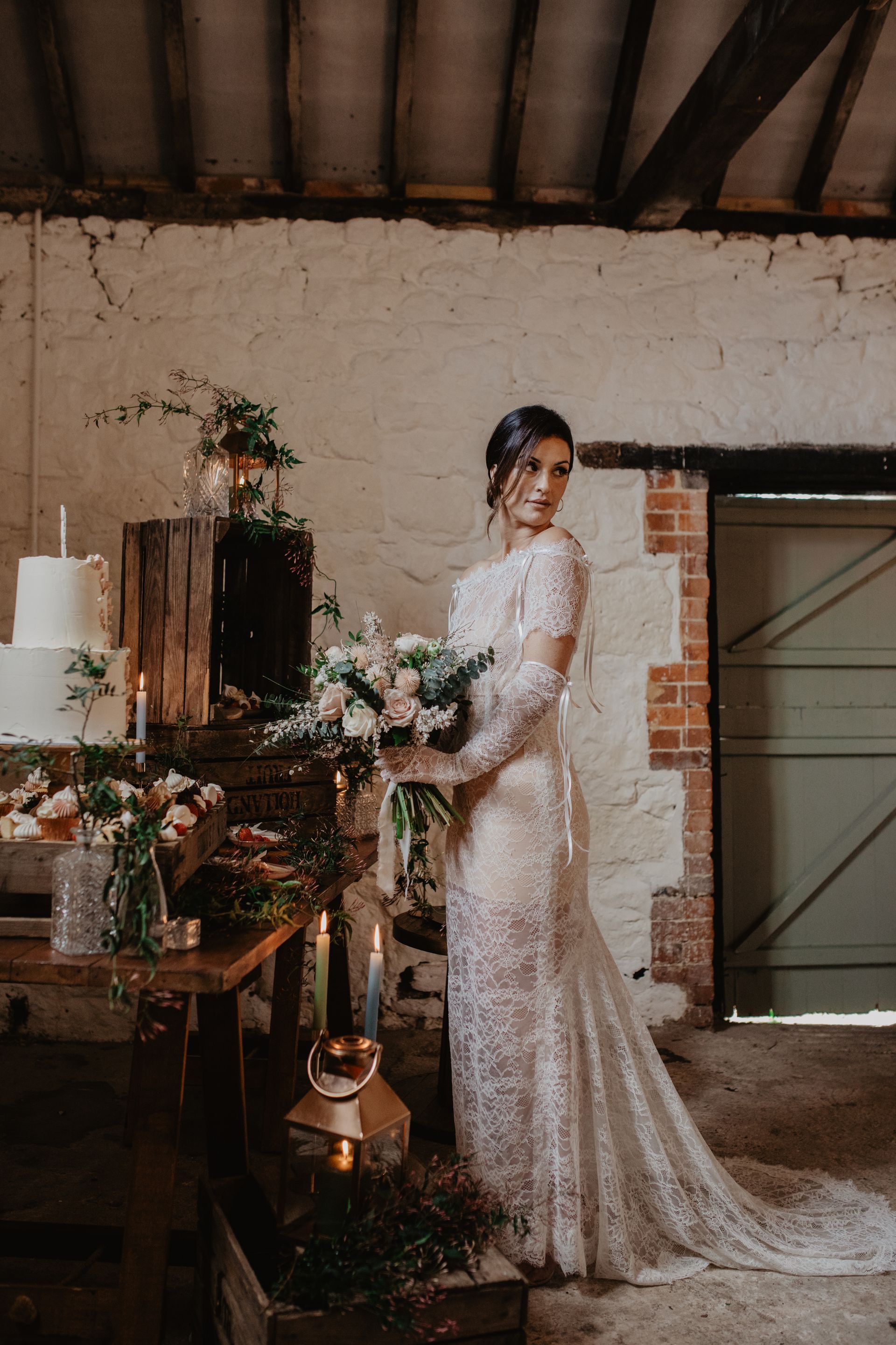 The bride is wearing a lace dress and holding a bouquet of flowers.