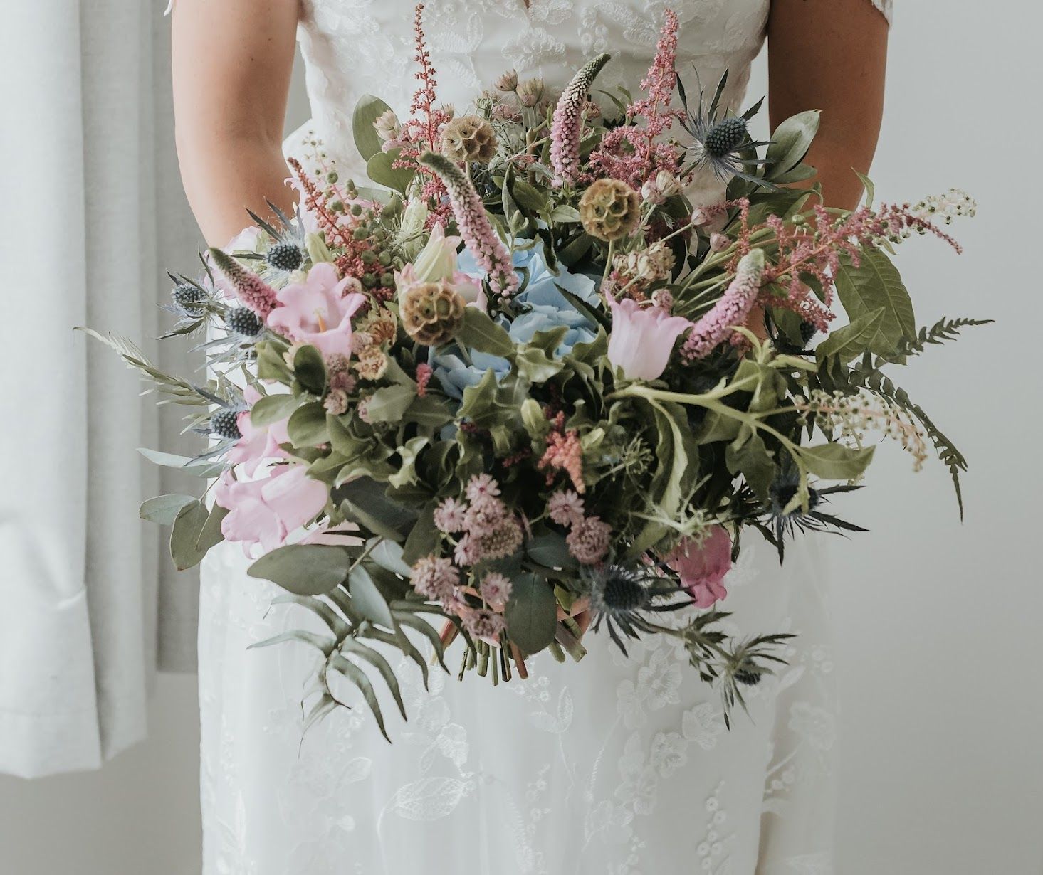 A bride in a white dress is holding a bouquet of flowers.