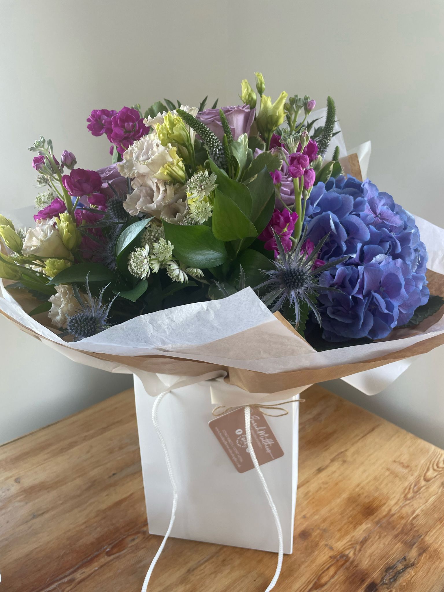 A bouquet of flowers is sitting on top of a wooden table.