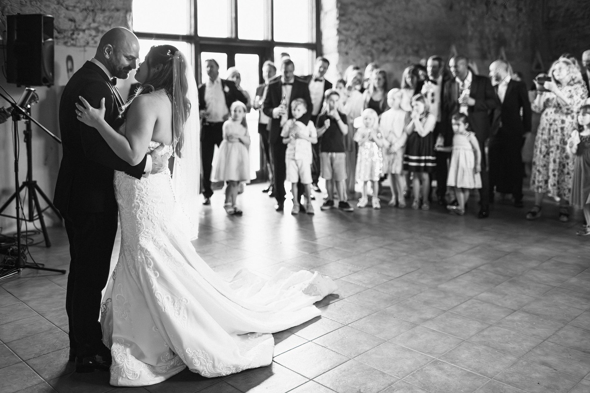 A black and white photo of a bride and groom dancing at their wedding reception.