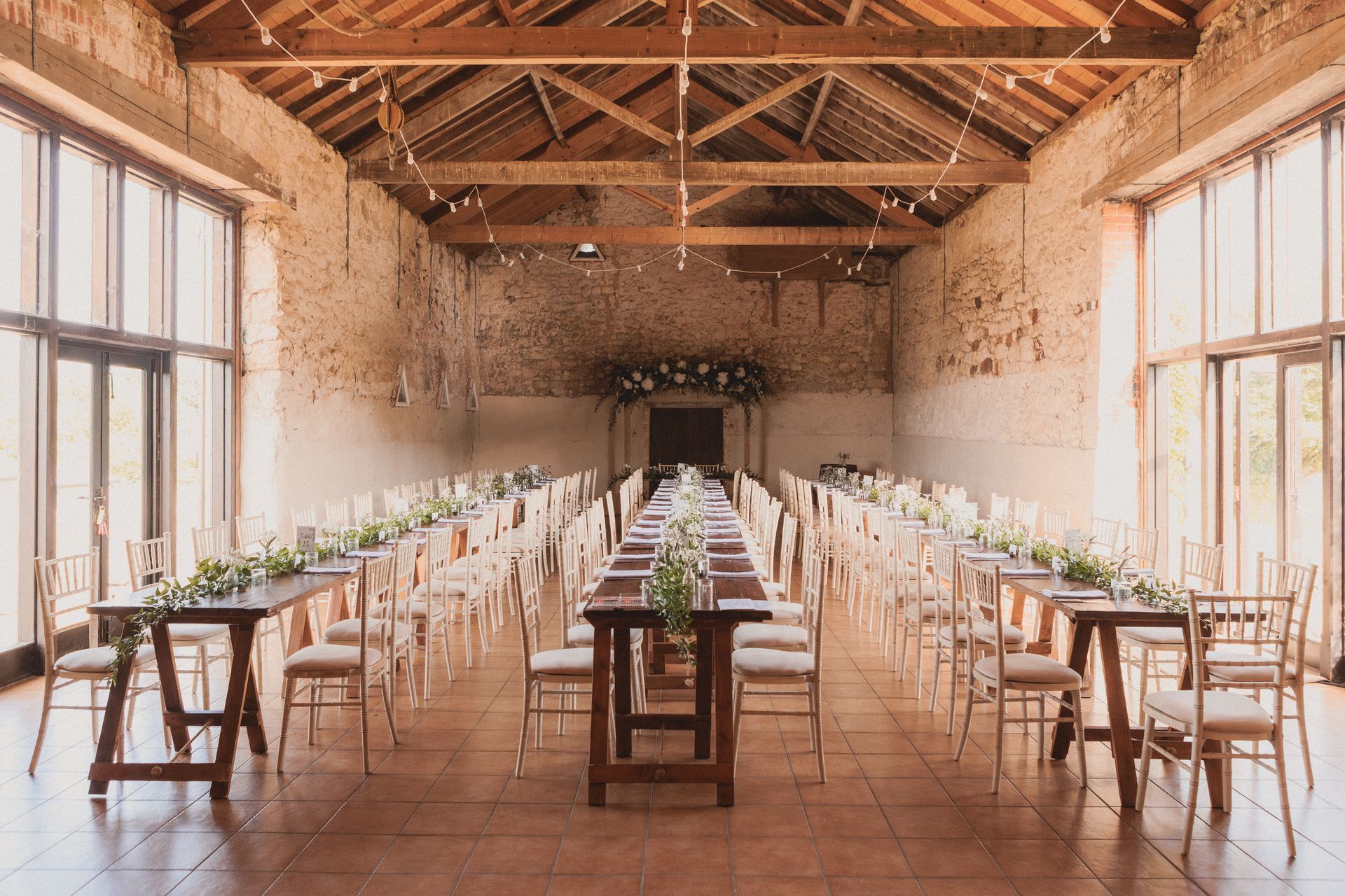 A large room with tables and chairs set up for a wedding reception.