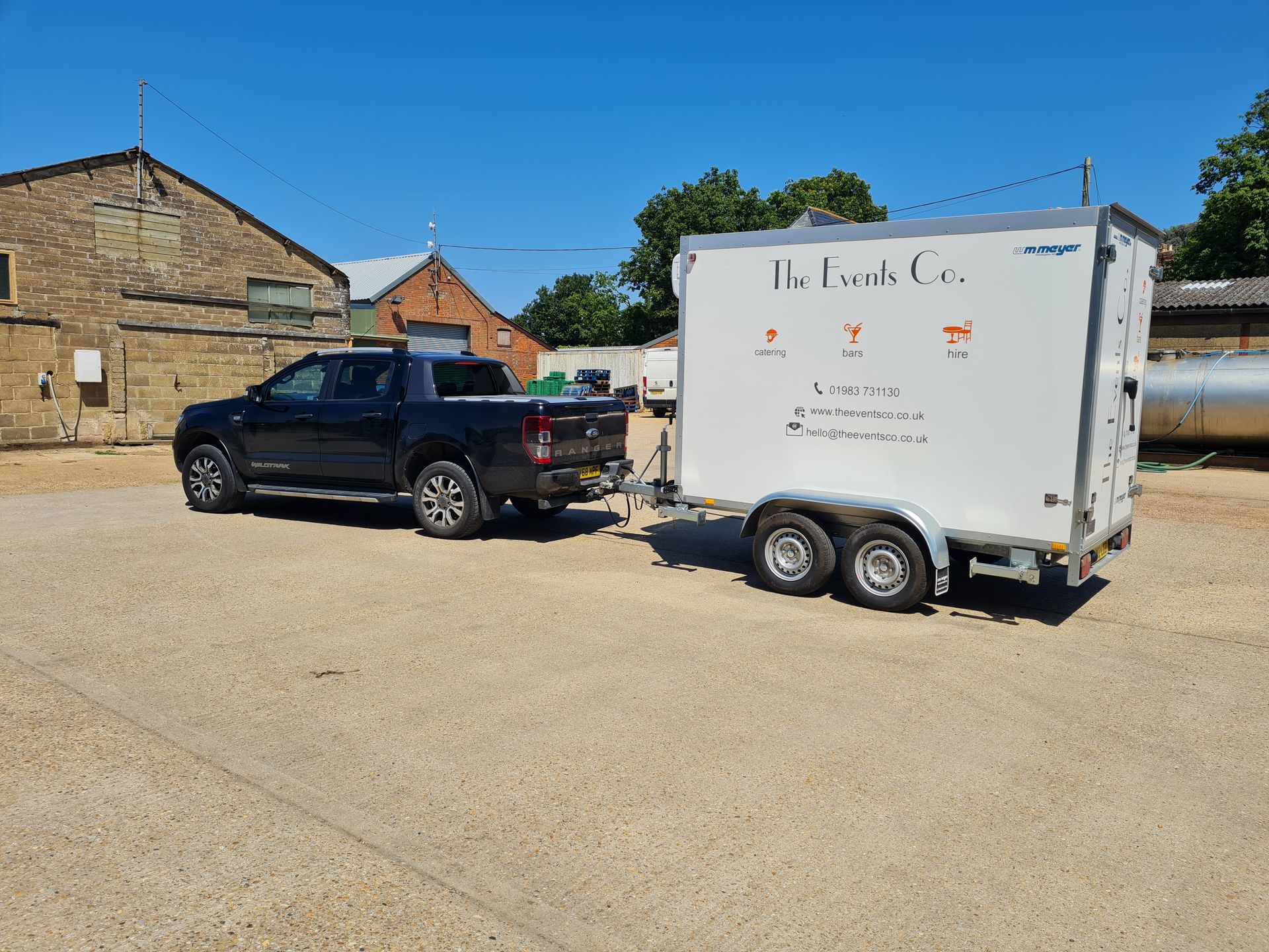 A truck with a trailer attached to it is parked in a parking lot.