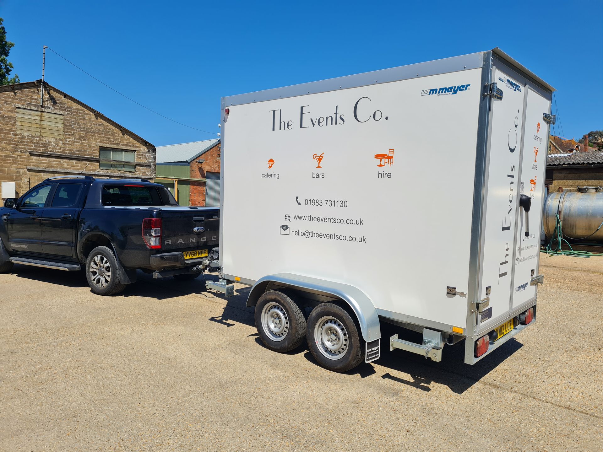 A truck is towing a trailer that says the events co. on it.