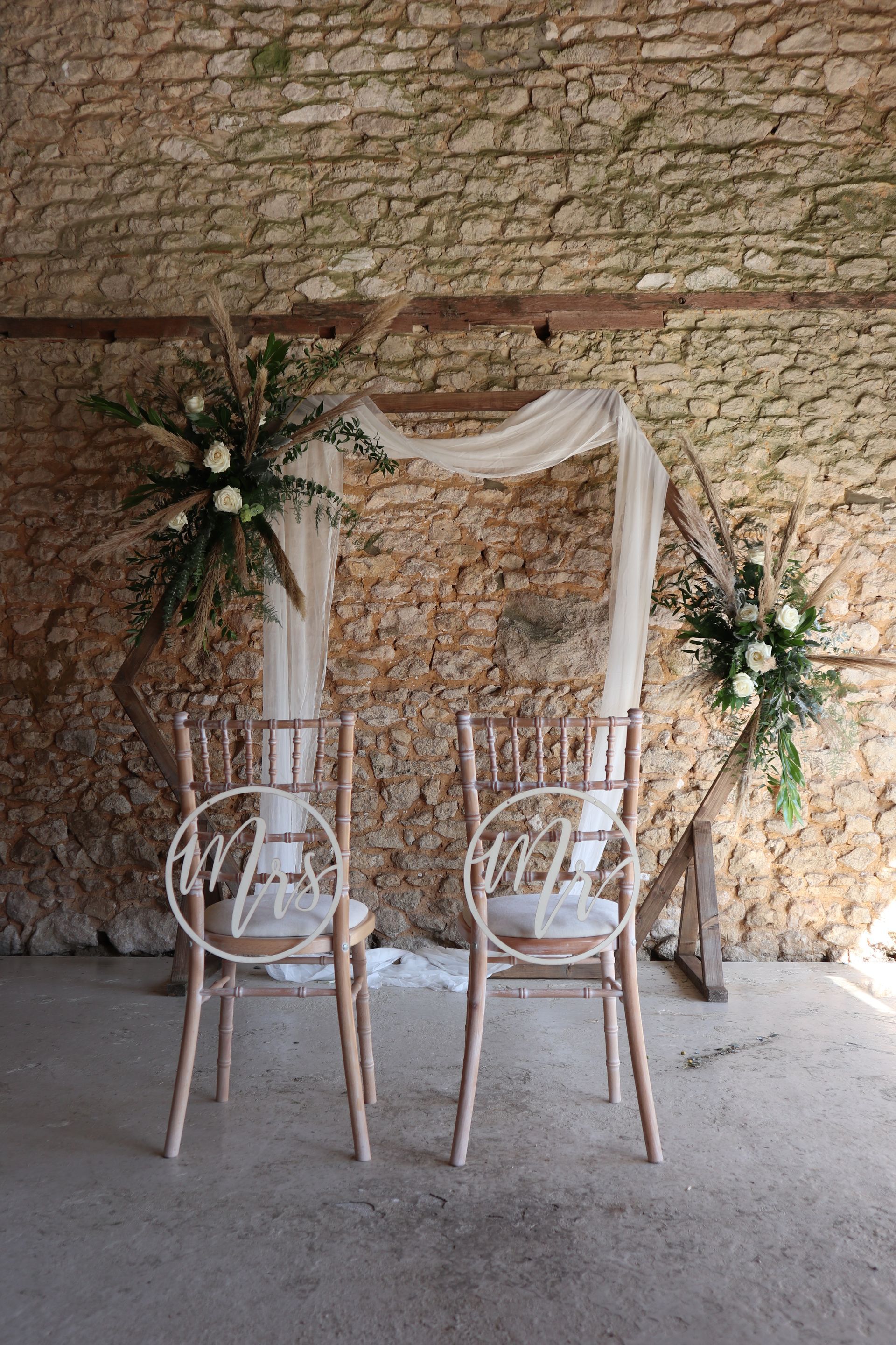 Two chairs are sitting in front of a stone wall.