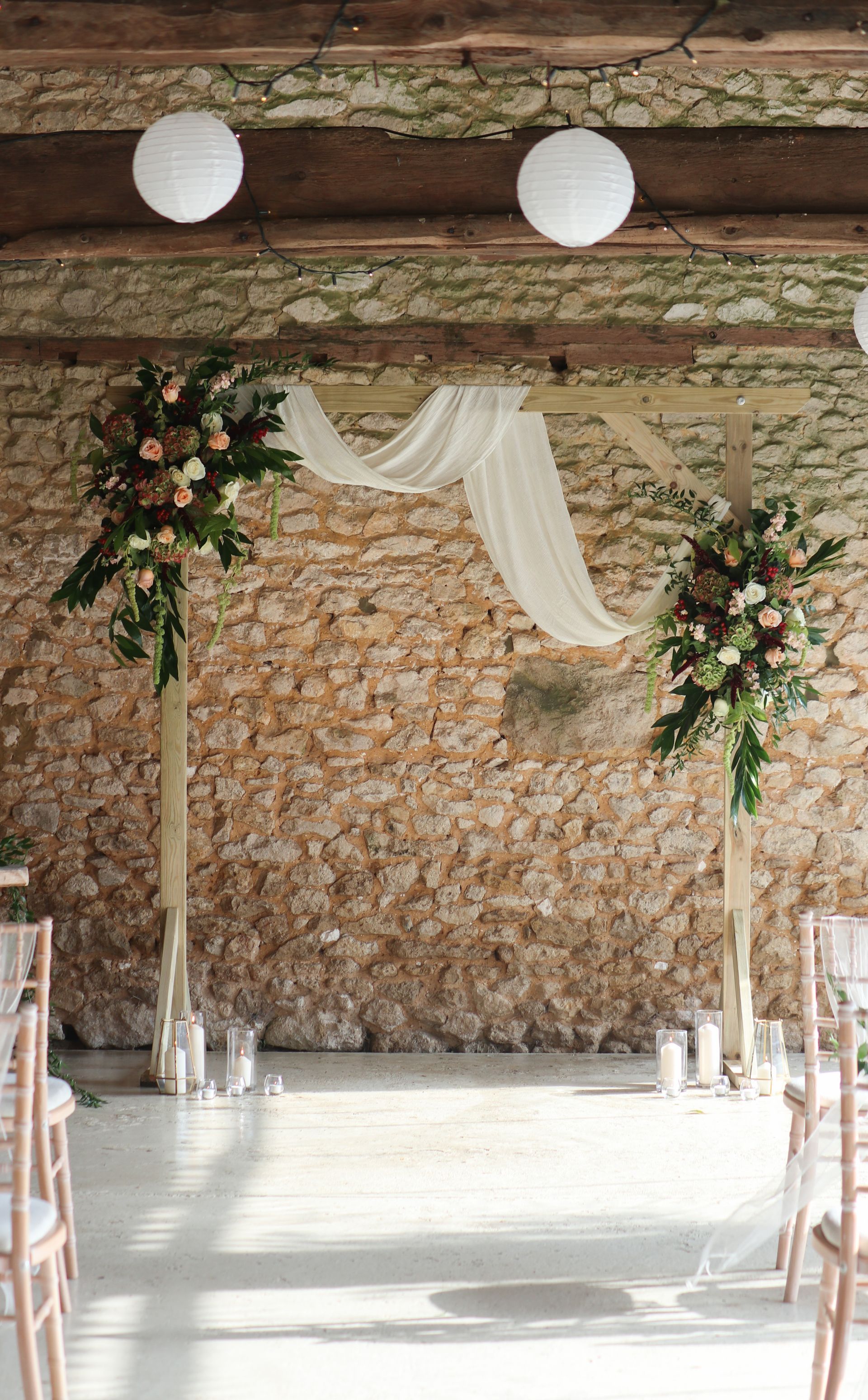 A room decorated for a wedding ceremony with flowers and lanterns.