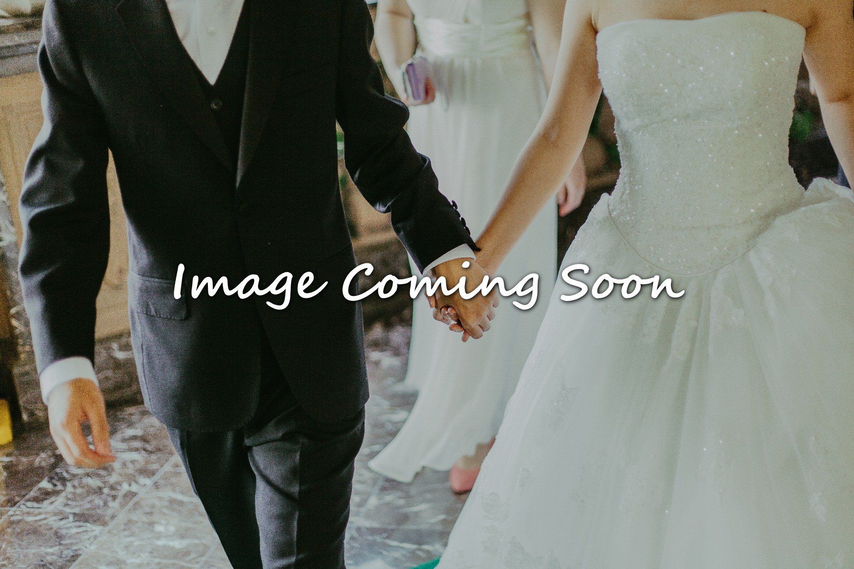 A bride and groom are holding hands in front of a sign that says image coming soon