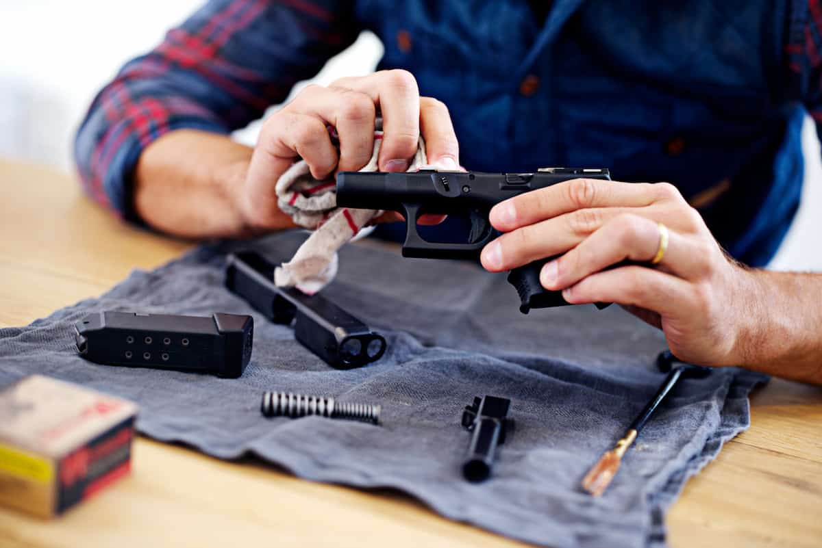A man is cleaning an air gun with a cloth