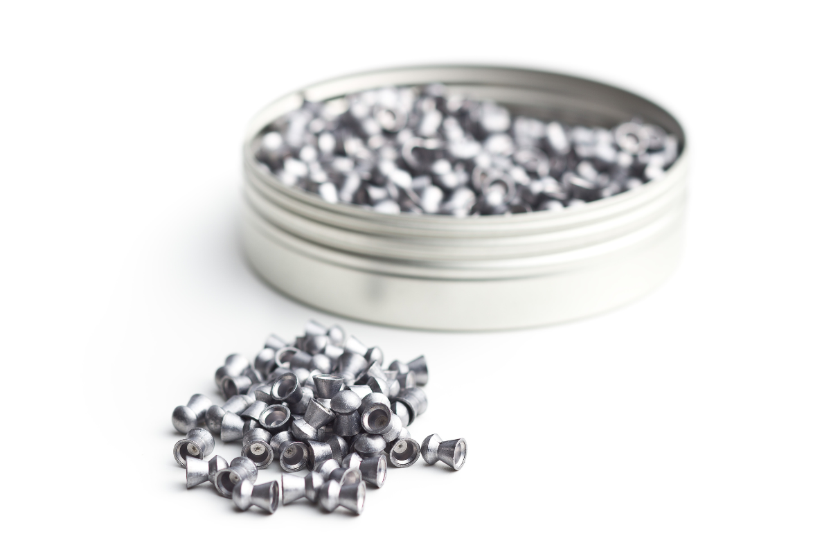 A metal container full of silver air gun pellets