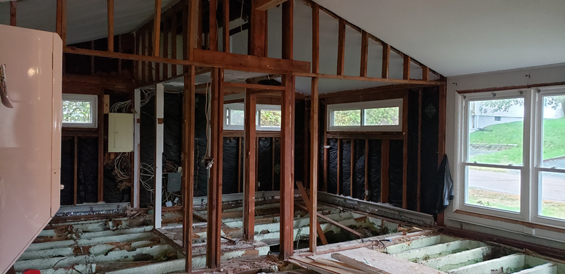 The inside of a house being remodeled with wooden beams and windows.