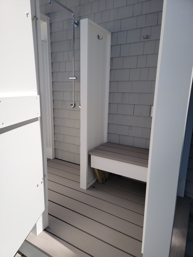 A bathroom with a bench and a shower stall
