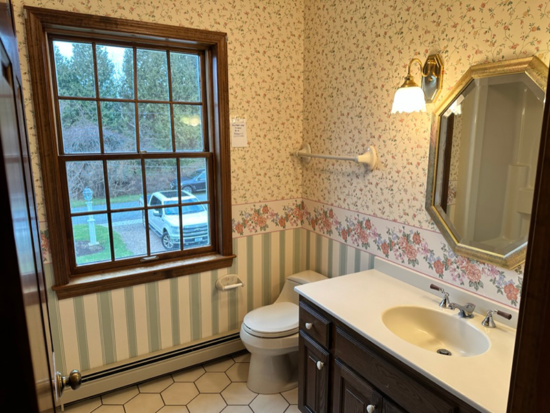 A bathroom with a toilet a sink and a window