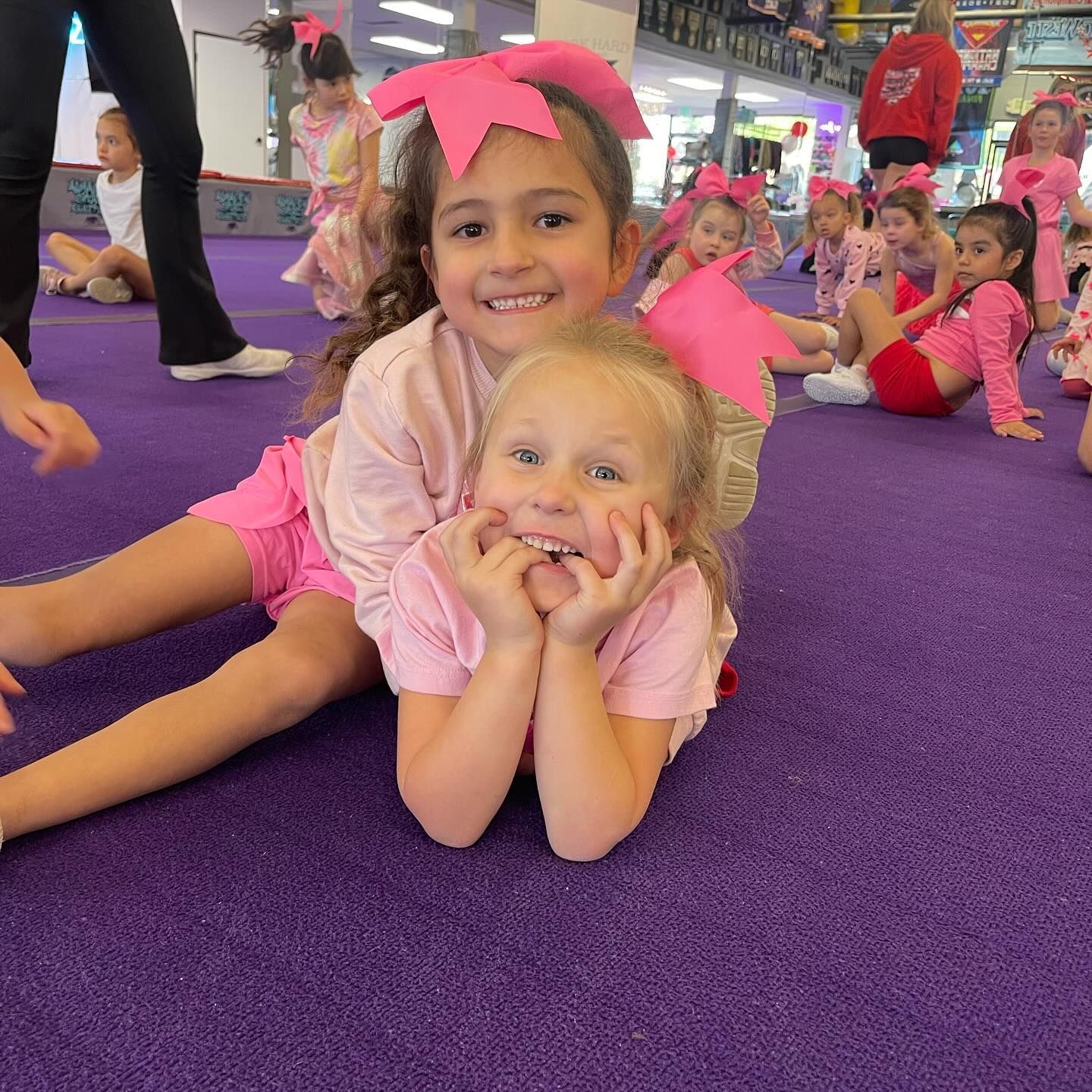 A group of little girls are laying on a purple carpet