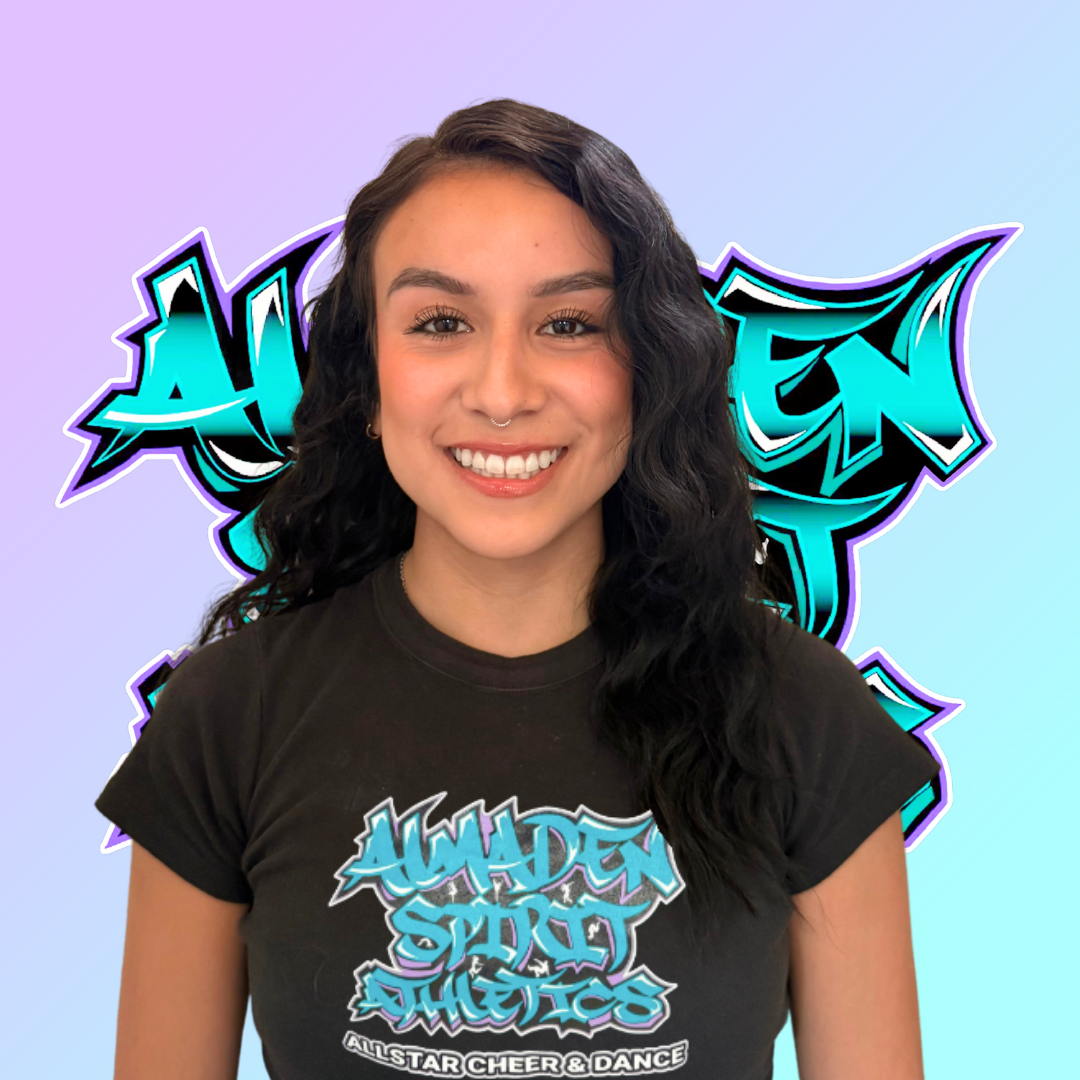 A woman wearing a black t-shirt with graffiti on it is smiling.