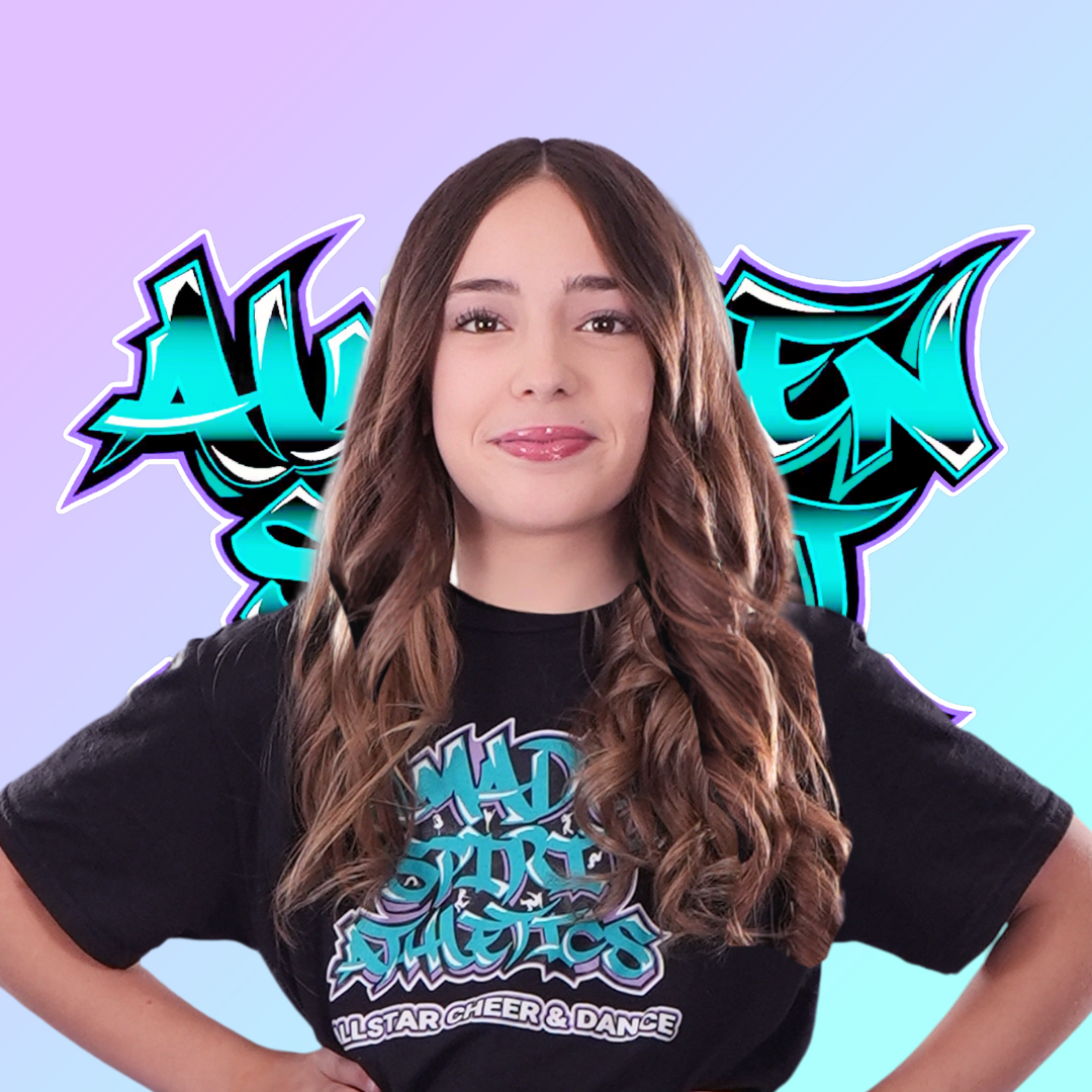 A young woman wearing a black t-shirt is smiling in front of a graffiti background.