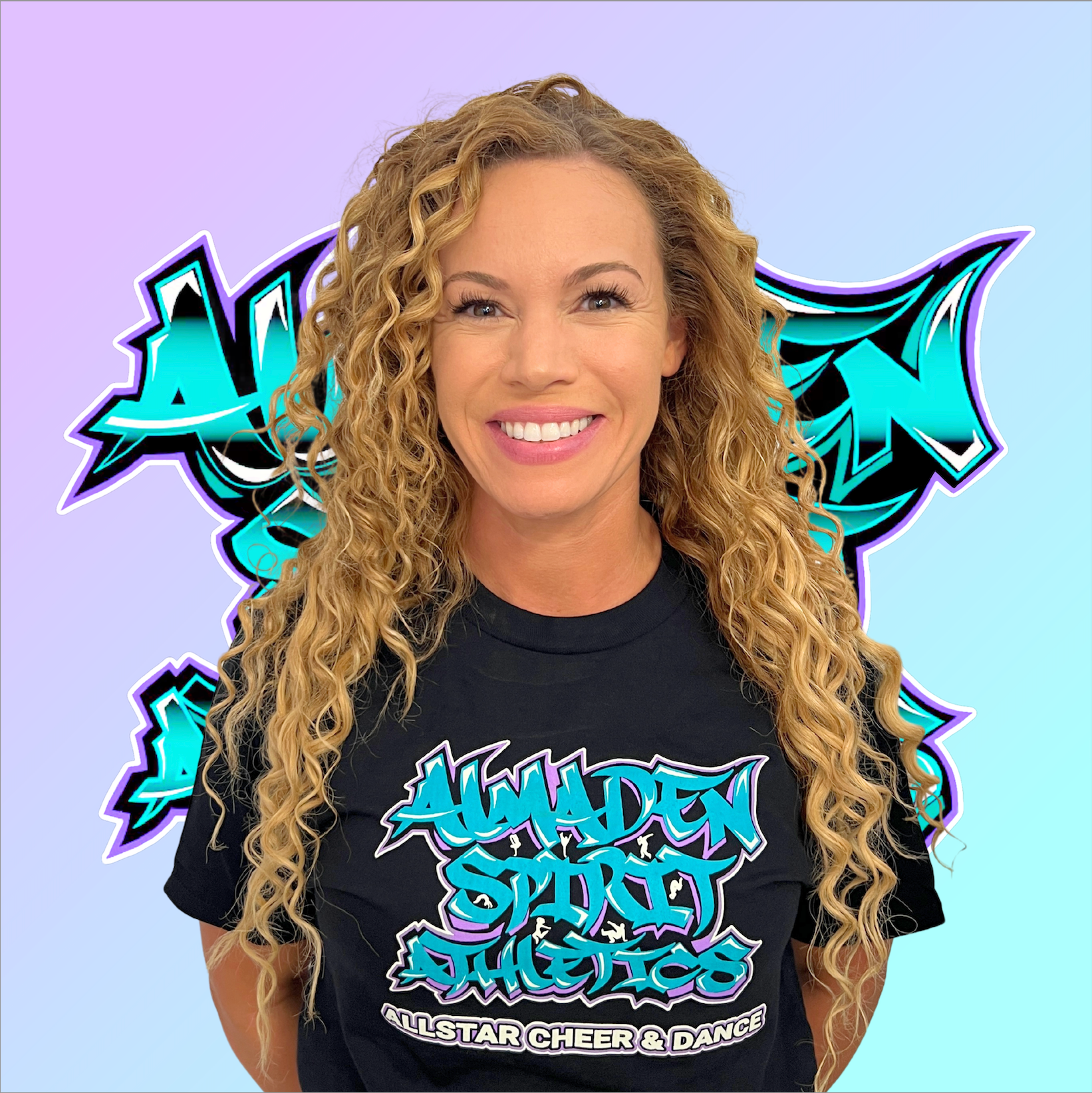 A woman with curly hair is wearing a black t-shirt with graffiti on it.