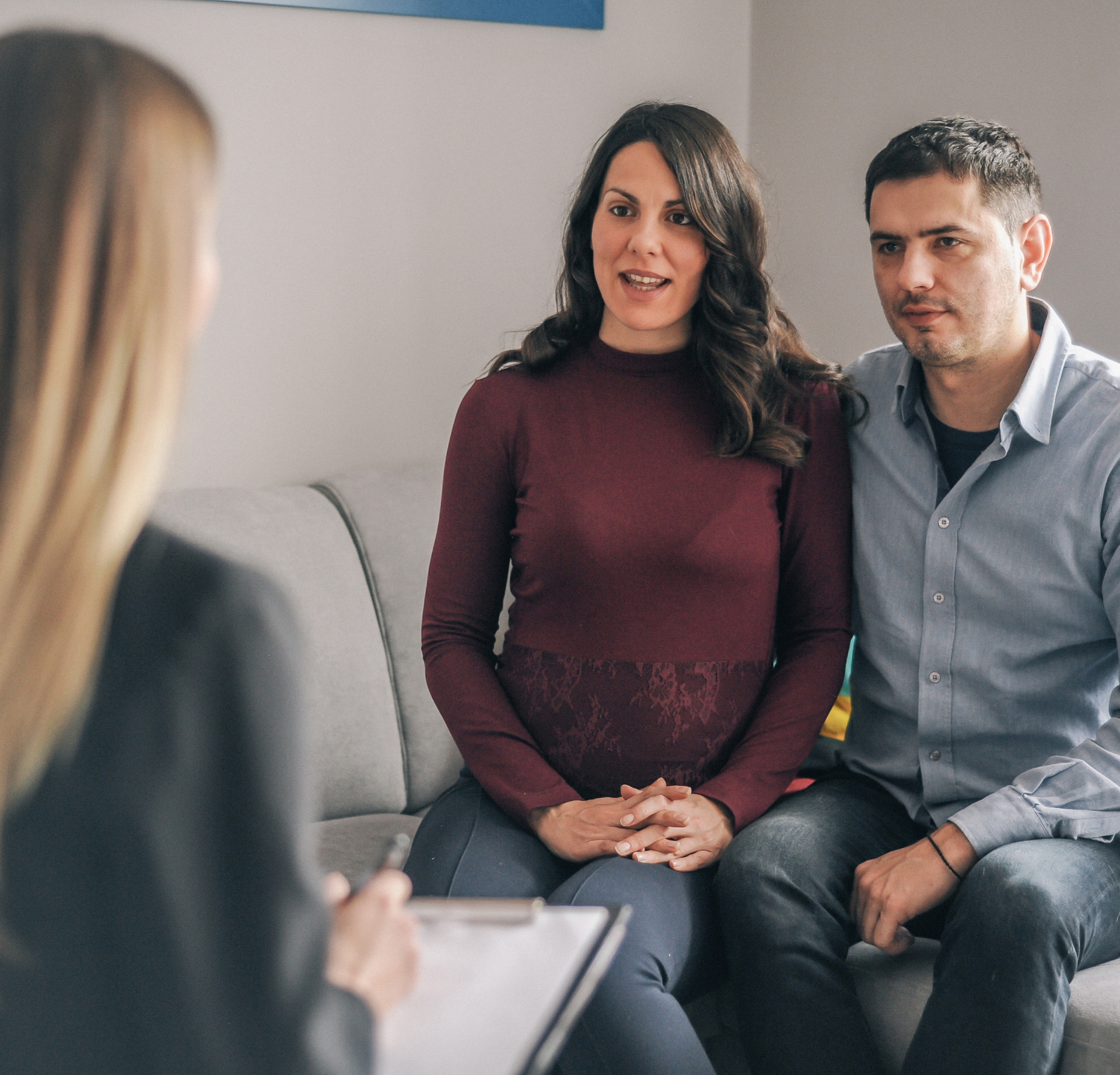 A professional speaks with a couple during a consultation in a bright office space.