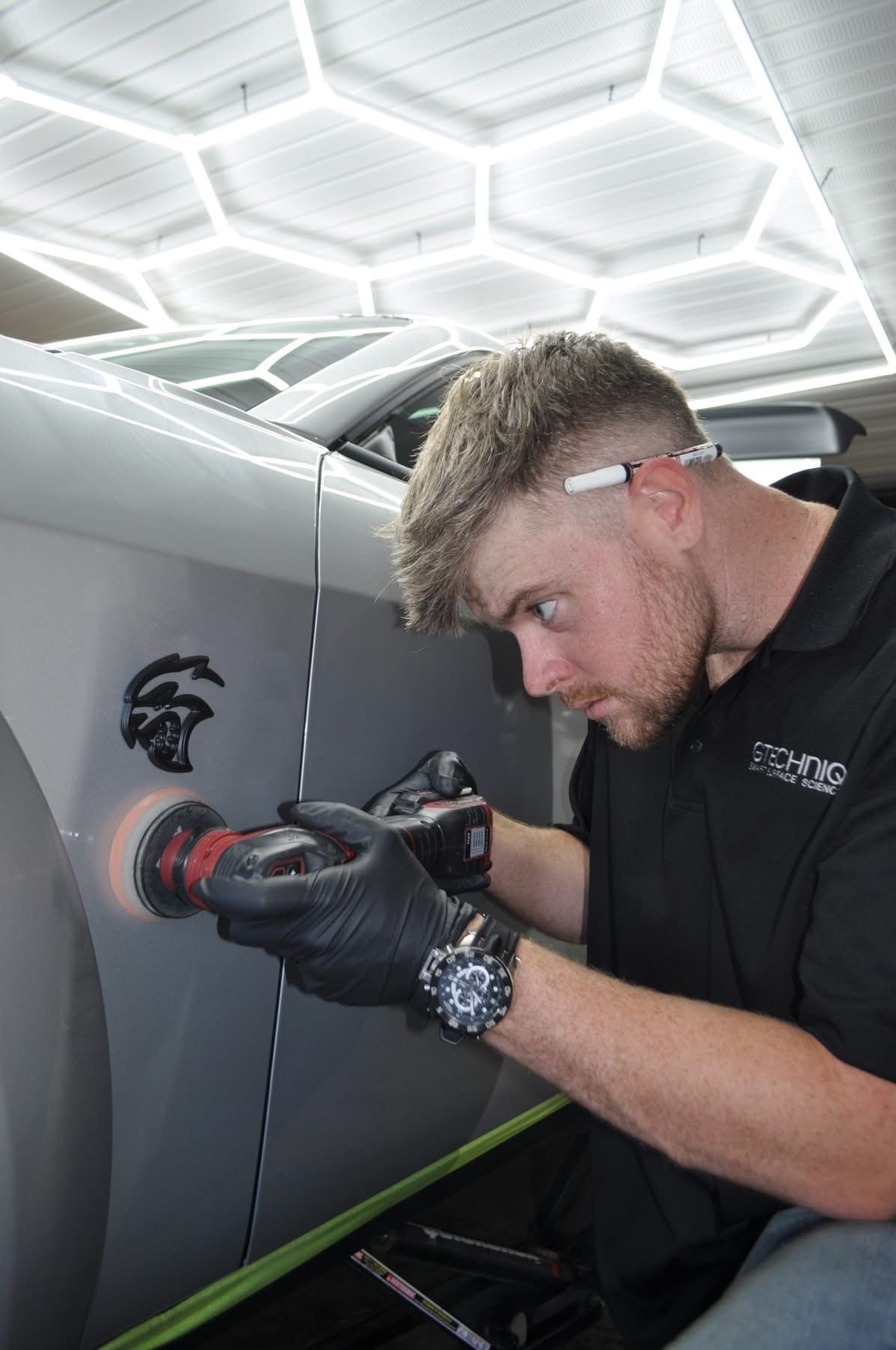 A man is polishing the side of a car.